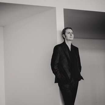 Peter Tuite angelehnt an einer Wand